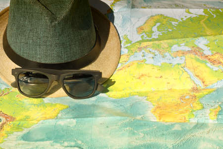 hat, saunglasses on map, holiday conceptの写真素材