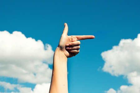 A hand shows the direction with rainbowの写真素材