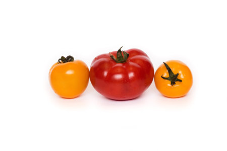 three fresh tomatoes with green leaves isolated on white backgroundの写真素材
