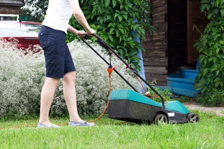 Lawn Mower at Work in gardenの写真素材