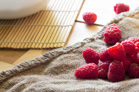 Red fresh raspberries on rustic wood background with copy space