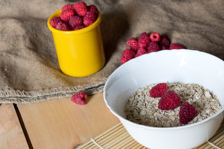 Bowl of Oatmeal, raspberries on the table with