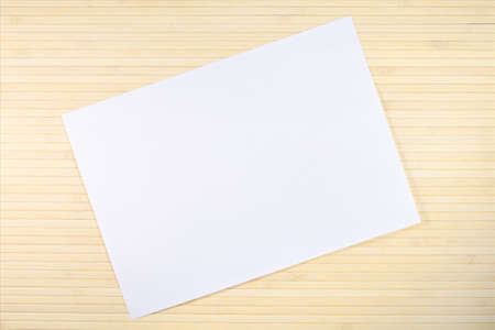 Blank sheet of paper on light wooden backgroundの写真素材