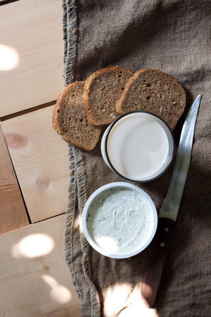 Rustic breakfast with wholegrain bread, milk and Cottage cheese on wooden background. Copy spaceの写真素材