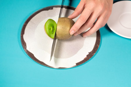 Fresh kiwi fruit sliced on turquoise backgroundの写真素材