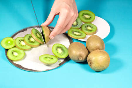 Fresh kiwi fruit sliced on turquoise backgroundの写真素材