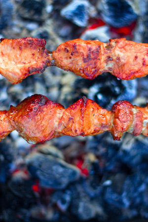 closeup of some meat skewers being grilled in a barbecueの写真素材