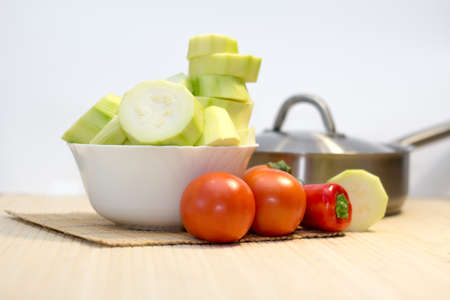Fresh sliced zucchini in bowl with tomatoo on Wooden cutting boardの写真素材