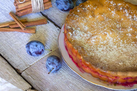 Still life with a homemade plum pie on rustic white wooden backgroundの写真素材