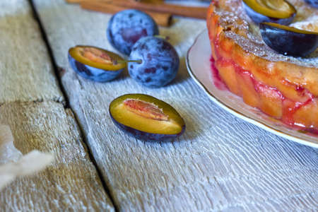 rustic plum cake on white wooden backgroundの写真素材