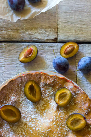 rustic plum cake on white wooden backgroundの写真素材