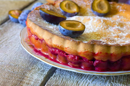Plum tart and fresh plums on rustic tableの写真素材