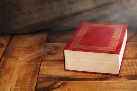 The old book on the table with light.の写真素材
