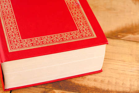Closed red book on wooden backgroundの写真素材