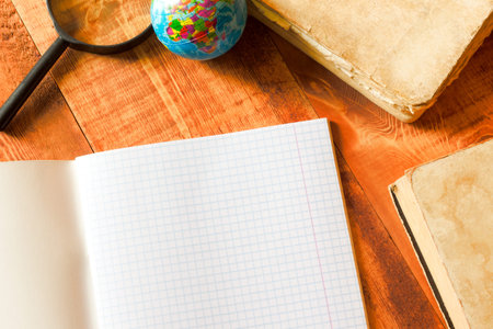 copy book, magnifying glass and globe on wooden tableの写真素材