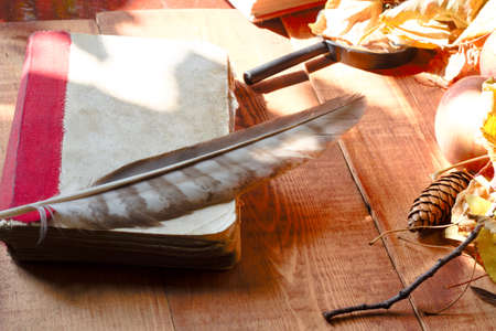 Feather pen with inkwell and old book of fairy taleson on wooden table closeupの写真素材