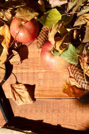Vintage autumn border from fallen leaves and apple on the old wooden table. Thanksgiving autumnal backgroundの写真素材