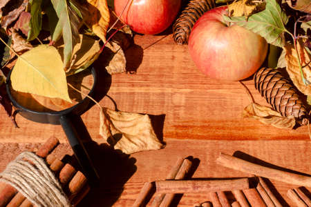 Ripe apples with cinnamon sticks on wooden table, on wooden backgroundの写真素材