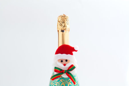 Champagne bottle with golden glittering splashes on white background. Flat lay. Minimal party concept.の写真素材
