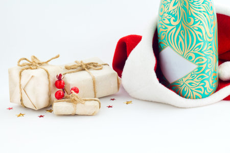 Christmas background with a santa hat, gift box, berries on white background