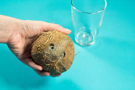 coconut milk is poured into a glass of coconut handの写真素材