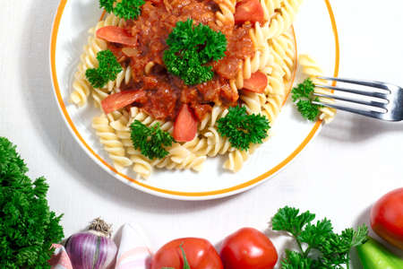 plate of penne pasta with tomato sauce on white backgroundの写真素材