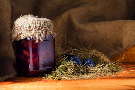 Sweet homemade plum jam and fruits on a wooden table.の写真素材