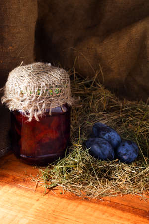 Sweet homemade plum jam and fruits on a wooden table.の写真素材