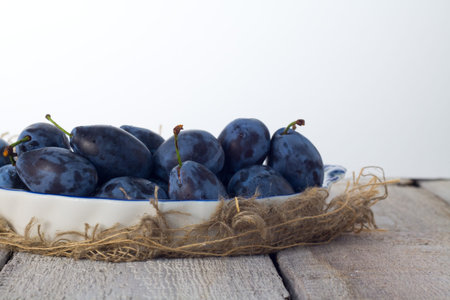 Plums ripe fresh on the wood texture background