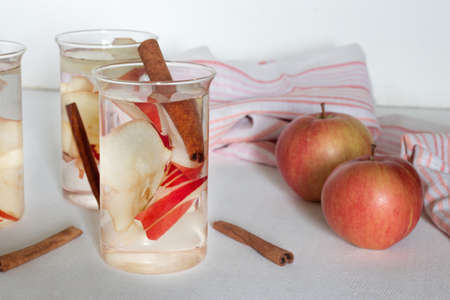 Autumnal thematic water with an apple, cinnamon in a glassの写真素材