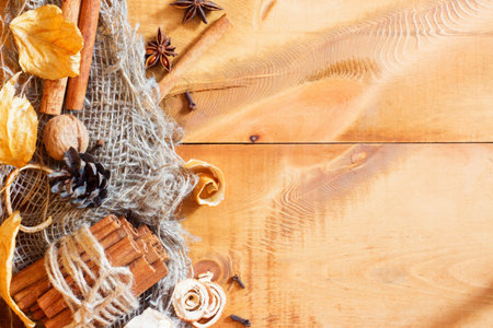 autumn background with colored leaves, nuts, cinnamon on wooden boardの写真素材