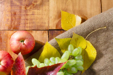 Apples on wooden table with autumn on wooden backgroundの写真素材