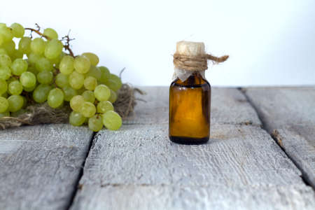 Essential oil of grape, vine, blue grapes, old wooden background, selective focusの写真素材