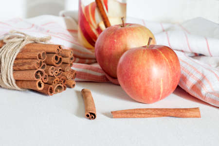 red apple and cinnamon on white tableの写真素材