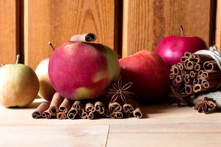 Fresh red and green apples, cinnamon sticks on wooden background.の写真素材