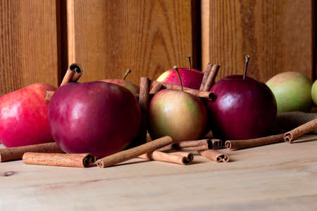 Fresh ripe red apple and cinnamon sticks on wooden background.の写真素材