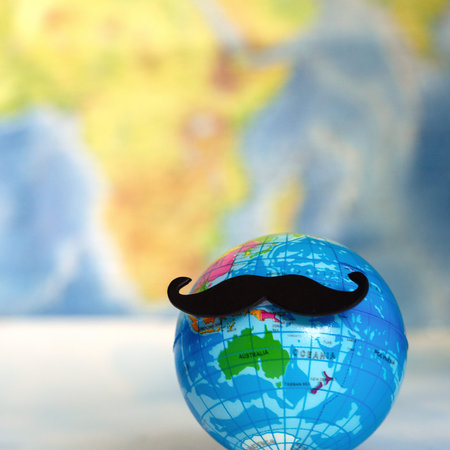 celebrating november awareness month - globe with a mustache on world map backgroundの写真素材