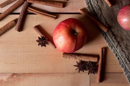 Fresh ripe red apples and cinnamon sticks on wooden background.の写真素材