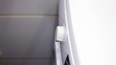 Close Up Of Man Choosing Cycle Program On Washing Machineの写真素材