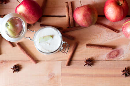 Healthy breakfast: yogurt with apples and cinnamon on wooden background.の写真素材