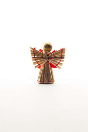 Angel toy woven from straw homemade on white backgroundの写真素材