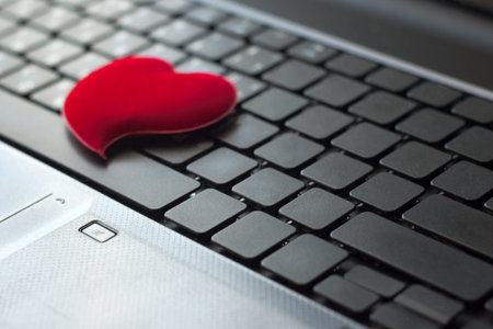 black Keyboard notebook with red heart . Love computers or type conceptの写真素材