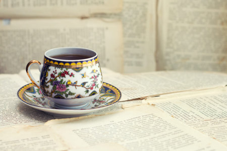 An old cup of coffee on the background of old sheets from the book . vintage coffee and book conceptの写真素材