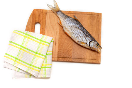 Salted dry fish on a wooden Board with a towel. Beer snack. Isolated on white background.