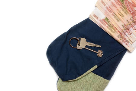 House keys on the background of Russian money and gloves for work. The concept of decent wages to working professionals.の写真素材