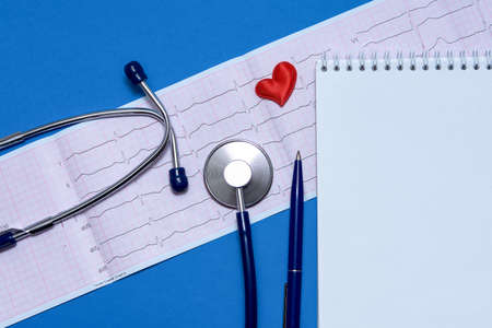 Close-up of healthy electrocardiogram results. A tool for studying breathing and heartbeat. Blue doctor's stethoscope. The concept of maintaining a healthy heart.の写真素材
