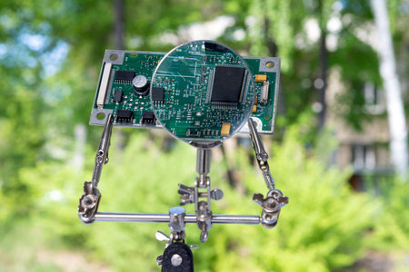 The microprocessors are fixed with a magnifying glass and robot hands against a background of green...