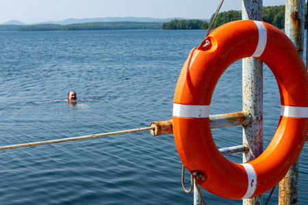 Lifebuoy hanging on the handle of the pier. The concept of saving drowning on the water.