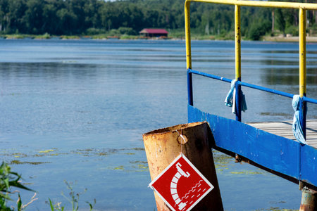 Wooden bridge on the lake shore, water intake sign for fire engines