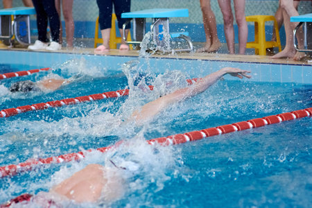 a beanie swimmer stretches his arms in the water during a breaststroke workout in the pool, blurred focusの写真素材